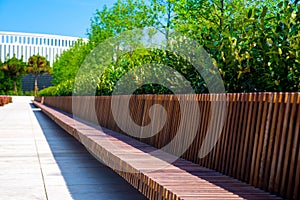 Modern curved shaped brown wooden outdoor design bench in green zone