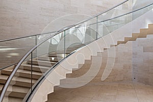 Modern curved staircase made form marble, steel and glass