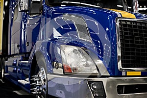 Modern dark blue custom semi truck tractor with lot of light ref