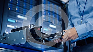 In the Modern Data Center: IT Engineer Installs New HDD Hard Drive and Other Hardware into Server