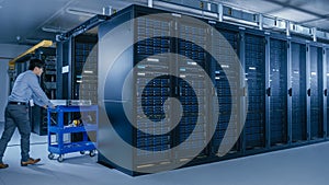 In the Modern Data Center: Team of IT Technicians Working with Server Racks, Running Maintenance a