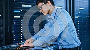 In the Modern Data Center: IT Technician Working with Server Racks, on a Pushcart Installing New H