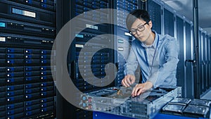 In the Modern Data Center: IT Technician Working with Server Racks, on a Pushcart Various Equipmen