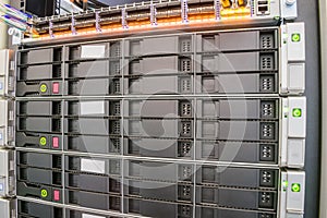 Modern database servers with multiple hard drives work in the server rack. The computing equipment is located in the data center.