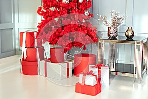 Modern decorated Red Christmas tree with gifts in living room. Happy new year interior background.