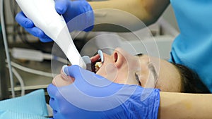 Modern dental clinic concept. Orthodontist using 3D intraoral scanner for scanning patient teeth. Manual teeth scanner