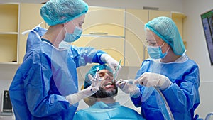 Modern dental clinic dentist woman make a anaesthesia for her patient before to start the work for a oral treatment her