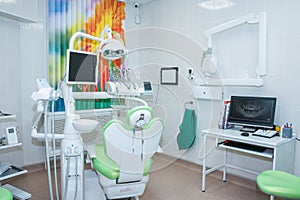 Modern dental office with green chair and professional tools