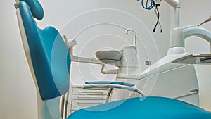 Modern dental office. Dental chair and other accessories used by dentists in blue, medical light