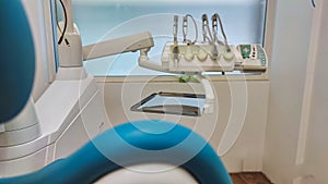 Modern dental office. Dental chair and other accessories used by dentists in blue, medical light