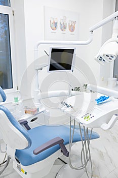 Modern dental practice. Dental chair and other accessories used by dentists in blue, copper light