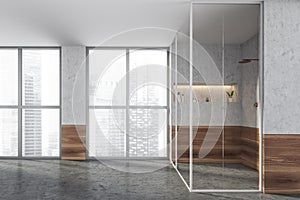 Modern design bathroom interior with shower cabin, bronze faucets. Panoramic window with skyscrapers city view. Wood and concrete