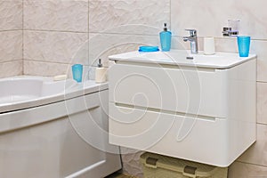 Modern design bathroom sink and bathtub in a modern residential building or hotel. Contemporary white sink with faucet and bathtub