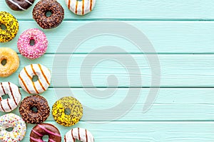 Modern design with bright donuts on mint green wooden background top view mock up