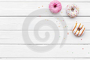 Modern design with bright donuts on white wooden background top view mock up