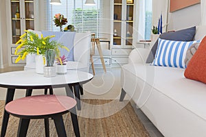 Modern design of living room with yellow,blue and orange pillow on sofa.