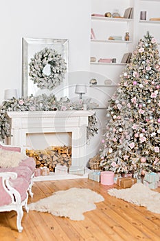 Modern design of the room with fireplace in light colors decorated with Christmas tree and decorative elements. New Year