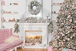 Modern design of the room with fireplace in light colors decorated with Christmas tree and decorative elements. New Year