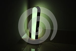 Modern desk lamp with green color light reflections on a wall