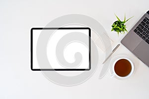 Modern desk workspace with blank copy space mockup with blank screen tablet, coffee cup, technology, headphones with