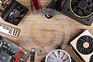 Modern desktop computer hardware components on wood desk table background. Circle shaped of pc parts like cpu fan cooler