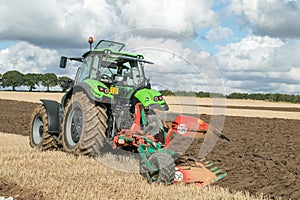 Modern deutz fahr tractor pulling a plough