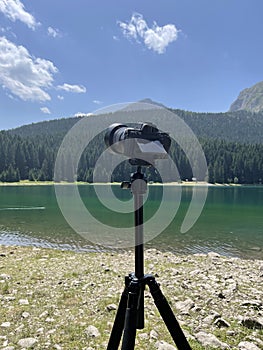 Modern digital camera mounted on a tripod captures the landscape while traveling