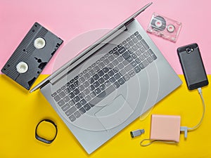 Modern digital gadgets, storage media, devaysy and obsolete analog media devices on a colored paper background. Top view. Flat lay