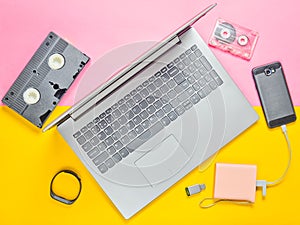 Modern digital gadgets, storage media, devaysy and obsolete analog media devices on a colored paper background. Top view.