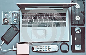 Modern digital gadgets, storage media, devaysy and obsolete analog media devices on a gray paper background. Top view. Flat lay.