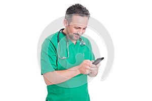 Modern doctor texting sms and reading on smartphone