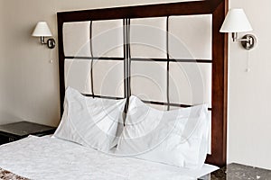 Modern double bedroom. Comfortable soft white pillows on a bed. Inside rooms of a apartment or hotel.