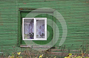 modern double-glazed windows on an old green wooden house.