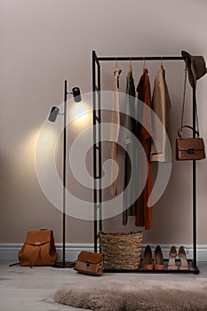 Modern dressing room interior with clothing rack near beige wall