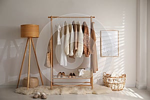 Modern dressing room interior with rack of stylish shoes and women`s clothes