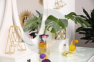 Modern dressing table with different cosmetic products and accessories. Stylish room interior