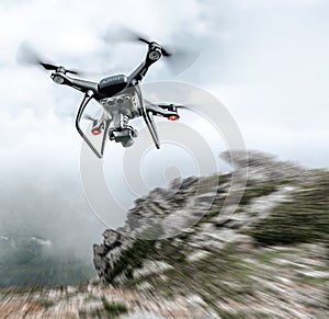 Modern drone flies in the mountains.