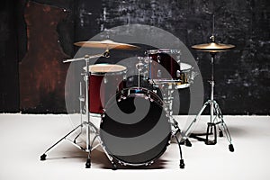 Modern drum set on black background in room