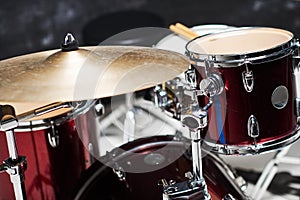 Modern drum set on black background in room