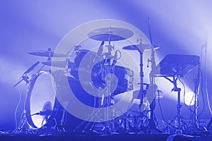 modern drum set of a rock band on stage in blue light