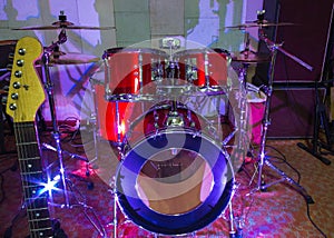 Modern drum set on stage prepared for playing in bright blue light