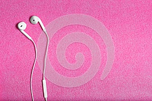 Modern earphones on the pink background