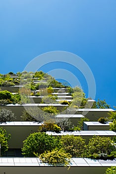 Modern and ecologic skyscrapers with many trees on every balcony