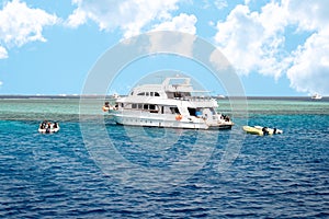 Modern Egyptian Diving Boat In The Sea Near Coral Reef Island. White Marine Pleasure Craft With Tourists In The Red Sea.