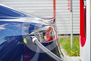 Modern electric car plugged to charging station