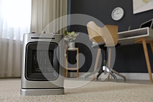Modern electric infrared heater on floor in room interior, closeup. space for text