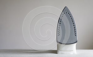 Modern electric iron on ironing board