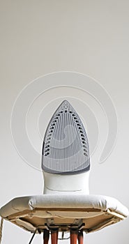 Modern electric iron on ironing board