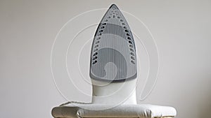 Modern electric iron on ironing board