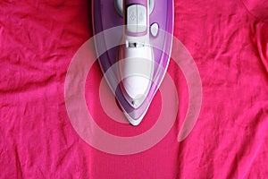 Modern electric iron on wrinkled cloth